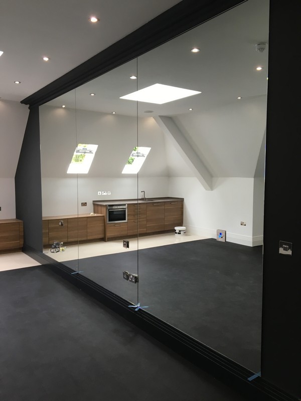 Frameless glass partition in loft conversion by Esher glaziers