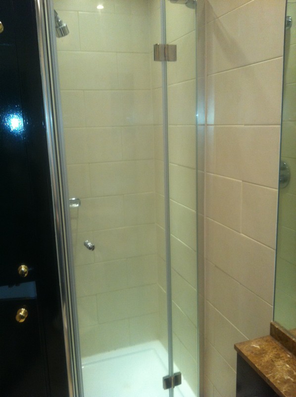Frameless glass shower enclosure with chrome fittings in Esher