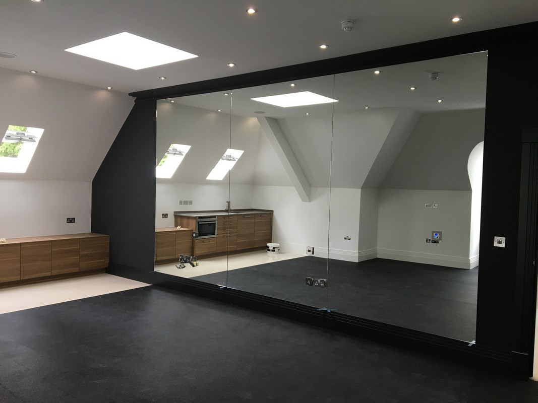 Frameless glass wall dividing loft conversion in Esher